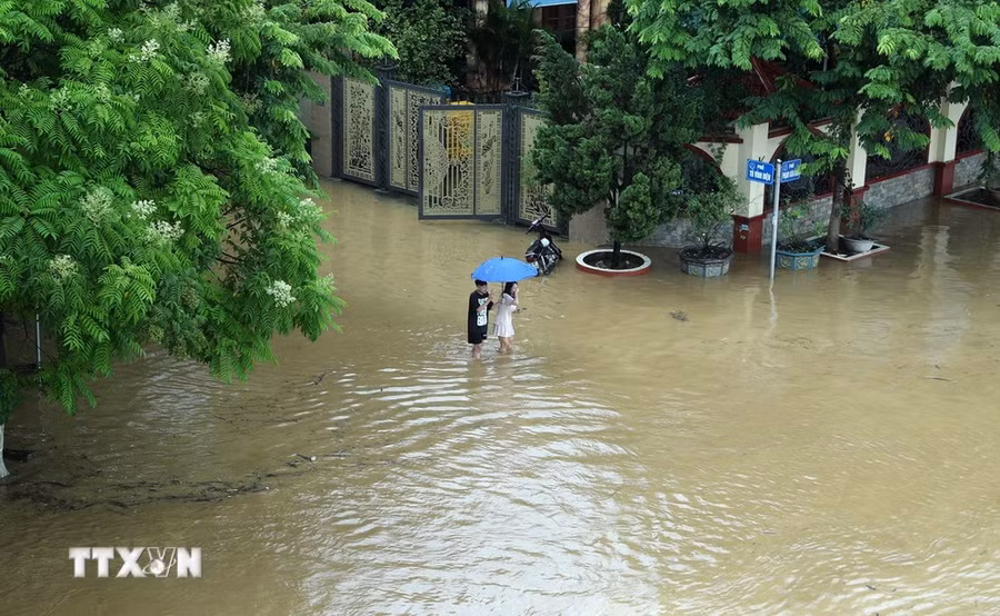 Đường Phạm Văn Xảo, phường Lào Cai, thành phố Lào Cai bị lũ tràn vào, ngập trong biển nước lúc 11g30 ngày 9/9 khiến người dân đi lại khó khăn. (Ảnh: Quốc Khánh/TTXVN) Đường Phạm Văn Xảo, phường Lào Cai, thành phố Lào Cai bị lũ tràn vào, ngập trong biển nước lúc 11g30 ngày 9/9 khiến người dân đi lại khó khăn. (Ảnh: Quốc Khánh/TTXVN)