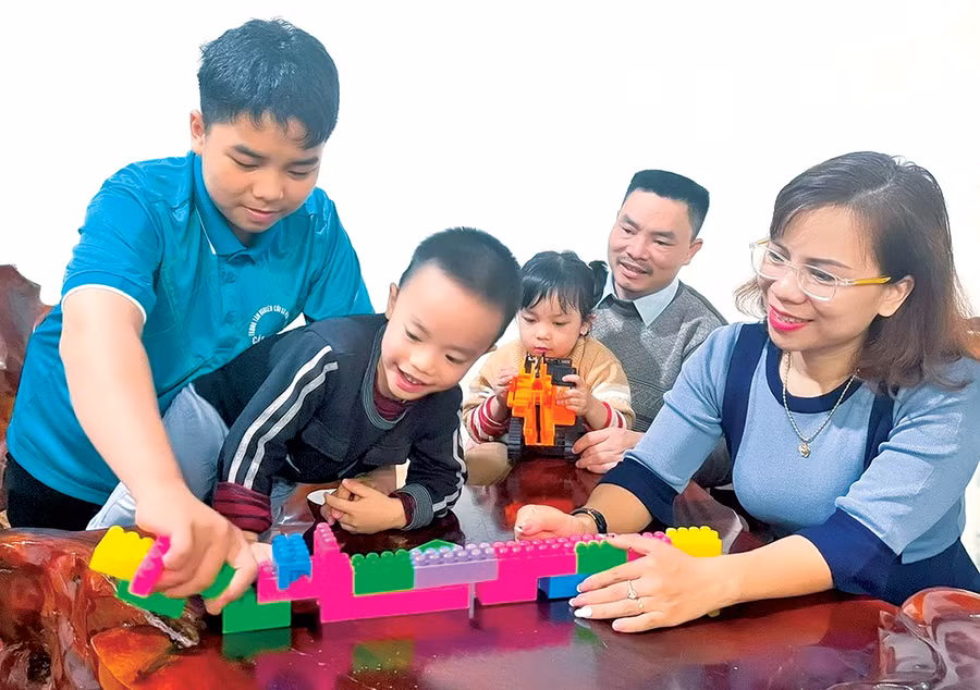 Anh Nguyễn Văn Long và chị Nguyễn Thị Cẩm Vân chơi cùng các con. Ảnh: P.D
