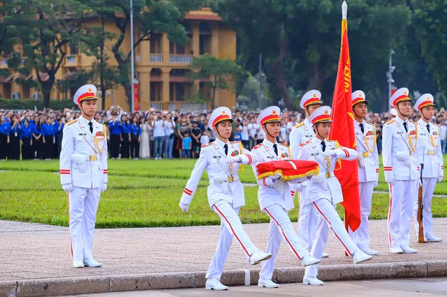 Ba thành viên đội tiêu binh bước lên khu vực cột cờ để tiến hành nghi lễ thượng cờ