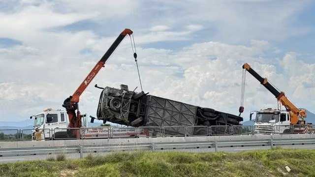 CSGT phải điều 2 xe cẩu loại nặng mới đưa được xe khách gặp nạn nằm dưới rãnh thoát nước lên trên. Ảnh: Q.H