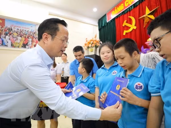 Giám đốc Sở Giáo dục và Đào tạo Hà Nội Trần Thế Cương trao tặng các món quà tới học sinh trường chuyên biệt trên địa bàn Thủ đô. (Ảnh: Thanh Tùng/TTXVN)