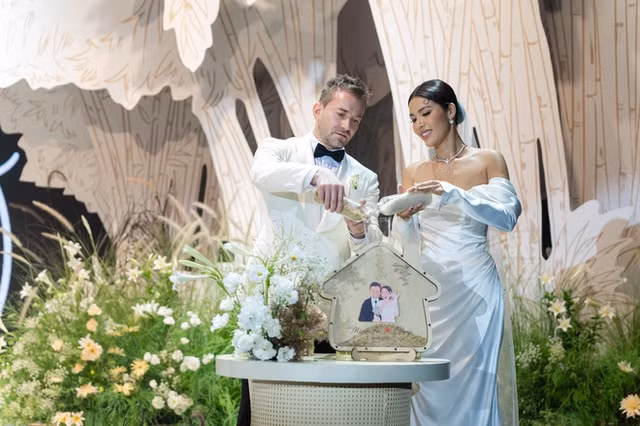 Cô dâu Minh Tú và chú rể Christopher cùng nhau thực hiện nghi thức "rót gạo" trong lễ cưới. Ảnh: ĐÀM GIA BẢO