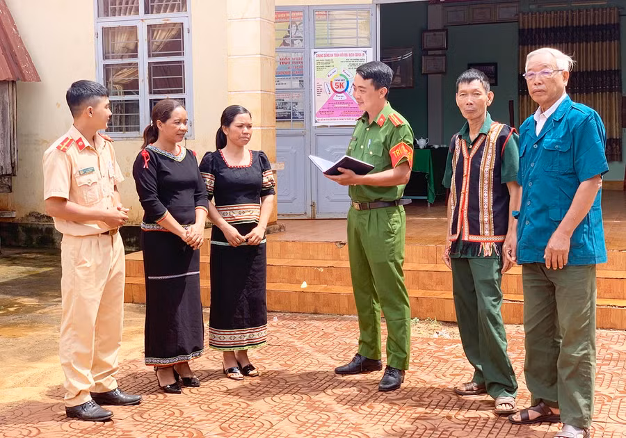 Cán bộ Công an huyện Chư Sê trao đổi công việc với dân làng Greo Sek, xã Dun. Ảnh: R'Ô HOK