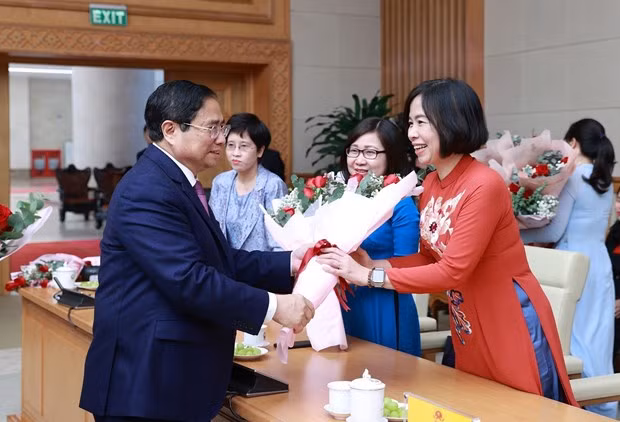 Thủ tướng Phạm Minh Chính tặng hoa chúc mừng Tổng giám đốc TTXVN Vũ Việt Trang và Phó TGĐ TTXVN Đoàn Thị Tuyết Nhung. (Ảnh: Dương Giang/TTXVN)