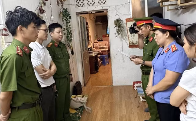 Công an tỉnh Thanh Hóa thi hành lệnh khởi tố, bắt tạm giam Đinh Văn Dương (áo trắng, đeo kính) để làm rõ hành vi lừa đảo trong chương trình xuất khẩu lao động đi Hàn Quốc. Ảnh: Công an Thanh Hóa