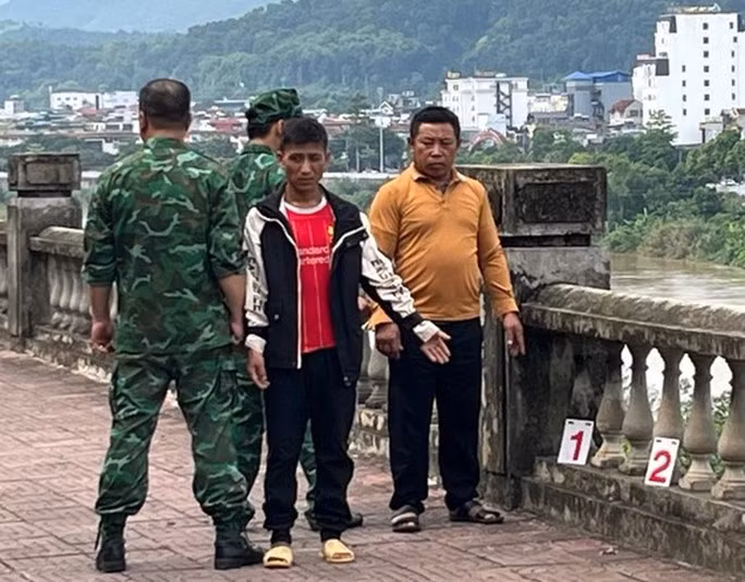 Cô gái trẻ bị người yêu lừa bán sang Trung Quốc - Ảnh 1. Thào A Dờ (áo đỏ) và Sùng A Sì đang thực nghiệm lại hành vi phạm tội của mình. Ảnh: Theo Báo Lào Cai