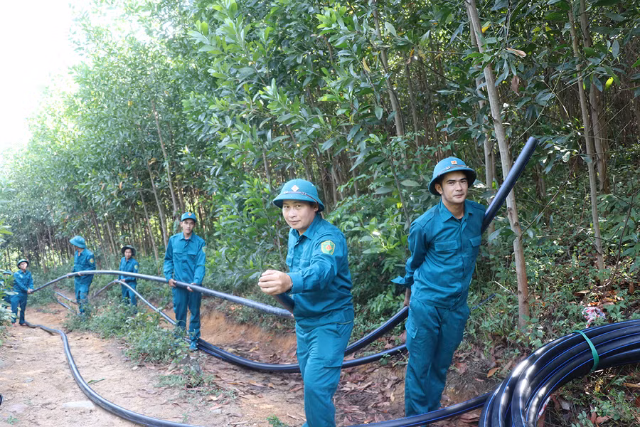 Lực lượng dân quân các xã, phường trên địa bàn thị xã An Khê kéo ống dẫn nước về làng Pốt. Ảnh: N.M