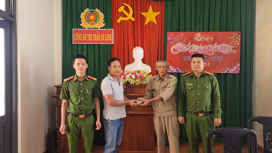 Ông Trần Hữu Dũng (thứ 2 từ phải qua) trao số tiền nhặt được cho anh Trần Trí Dũng