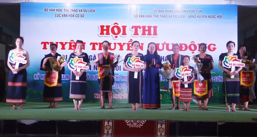 Lãnh đạo UBND huyện tặng hoa và cờ lưu niệm cho các đoàn nghệ nhân tham gia Ngày hội. Ảnh: QĐ