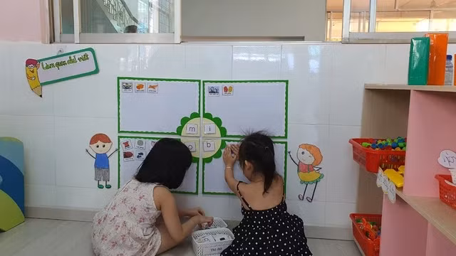 Trẻ làm quen chữ viết thông qua các trò chơi, hoạt động ở trường mầm non. Ảnh: THÚY HẰNG