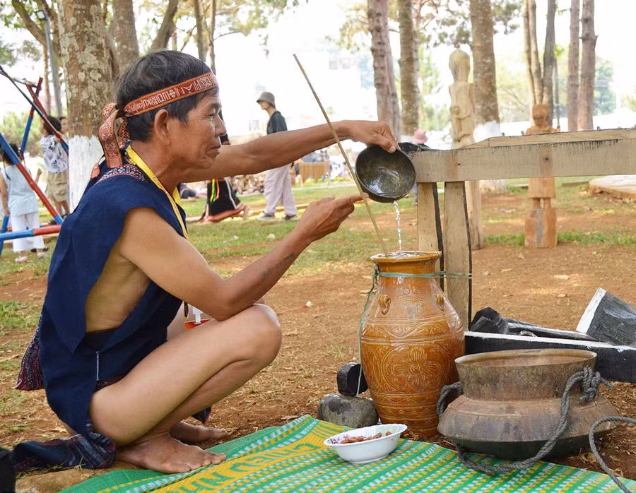 Già làng Đinh Vút (xã Yang Bắc, huyện Đak Pơ) đổ nước vào ché rượu. Ảnh: X.T