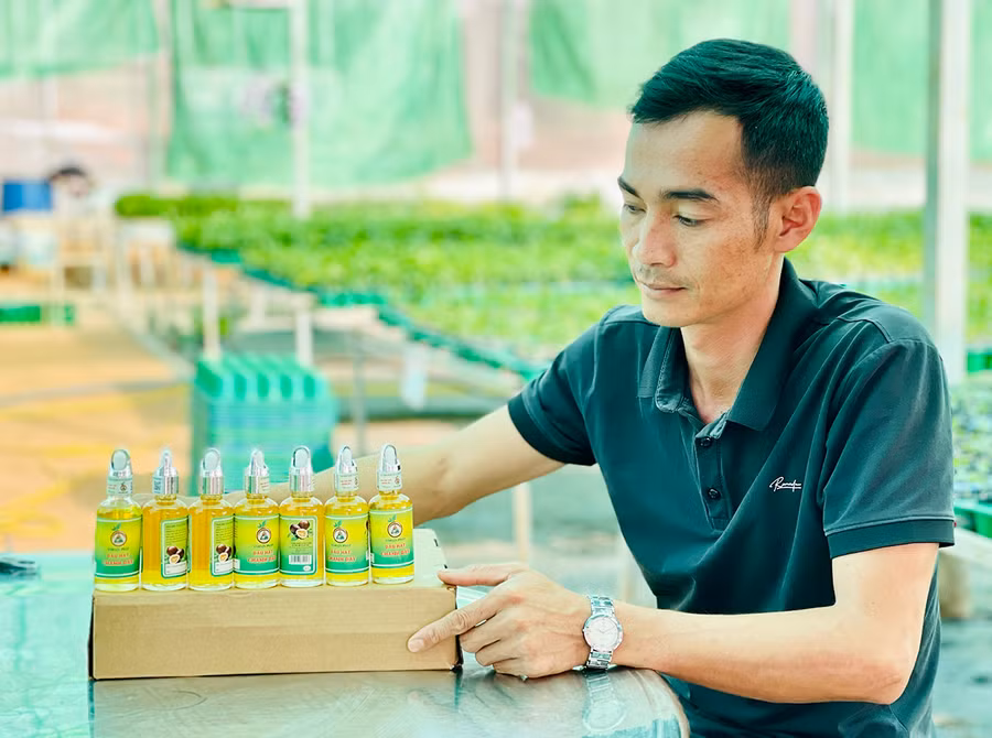 Anh Trần Mạnh Hưng-Giám đốc HTX Nông nghiệp dịch vụ thương mại tổng hợp Tân Lộc Phát bên sản phẩm dầu chanh dây ép lạnh. Ảnh: Mai Ka