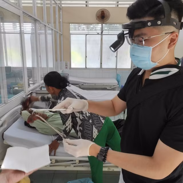 Bác sĩ gắp dị vật là con cá rô ra khỏi họng bệnh nhân. ẢNH TRUNG TÂM Y TẾ H.GIỒNG RIỀNG CUNG CẤP
