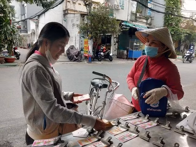 Nhiều năm bán vé số dạo cùng con gái, bà Đinh Thị Dung mòn mỏi mong có được bảo hiểm y tế từ công ty xổ số kiến thiết. Ảnh: Như Lịch Nhiều năm bán vé số dạo cùng con gái, bà Đinh Thị Dung mòn mỏi mong có được bảo hiểm y tế từ công ty xổ số kiến thiết. Ảnh: Như Lịch