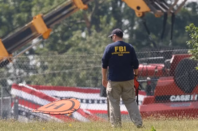 Một nhân viên thu thập bằng chứng của FBI tại hiện trường sau vụ ám sát hụt ông Trump - Ảnh: REUTERS