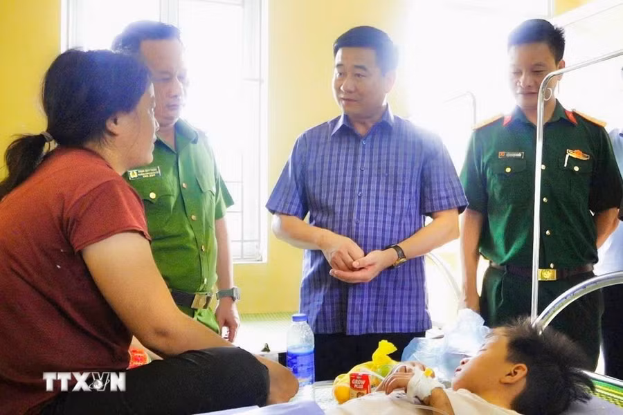 Lãnh đạo huyện Văn Yên thăm hỏi cháu Đặng Tiến Lâm tại Trung tâm y tế xã Lâm Giang. (Ảnh: TTXVN phát)