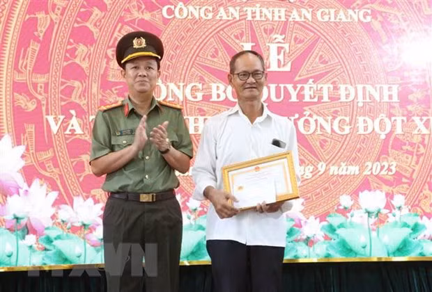 Đại tá Lê Phú Thạnh, Phó Giám đốc Công an tỉnh An Giang tặng Giấy khen của Giám đốc Công an tỉnh An Giang cho ông Bùi Ngọc Thọ. (Ảnh: Công Mạo/TTXVN)