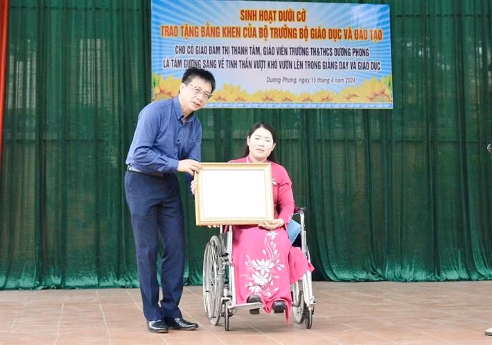 Chủ tịch Công đoàn Giáo dục Việt Nam Nguyễn Ngọc Ân trao Bằng khen của Bộ trưởng Bộ GD-ĐT cho cô giáo Đàm Thị Thanh Tâm.