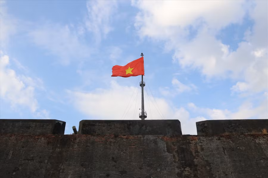Trước đây, phần cột cờ được làm bằng gỗ, về sau được đổi lại thành ống gang. Tuy nhiên, qua thời gian dài bị chiến tranh tàn phá, cột cờ hiện tại được xây dựng lại bằng sắt kiên cố và vững chãi hơn.