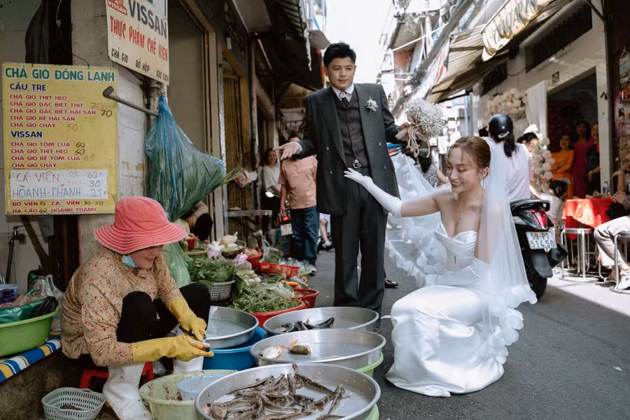 Những tiểu thương trong chợ hầu hết đều quen biết với cô dâu, chú rể và hỗ trợ họ nhiệt tình để có những bức ảnh lưu giữ kỷ niệm trong ngày vui. Ảnh: TAMO Studio