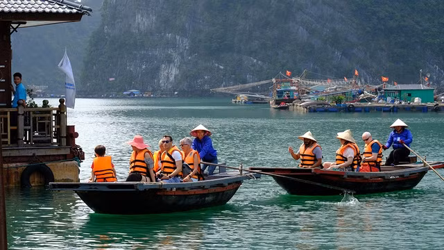 Du khách nước ngoài khám phá làng nổi Cửa Vạn. Ảnh: LNH