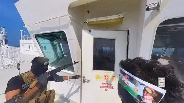 Các thành viên Houthi mở cửa buồng lái trên boong tàu ở biển Đỏ, trong ảnh được công bố ngày 20.11.2023.