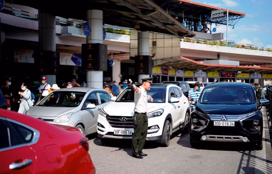 Nhân viên an ninh hàng không phân làn phương tiện đi vào làn đỗ tại Nhà ga T1 Sân bay Quốc tế Nội Bài. (Ảnh: CTV/Vietnam+)