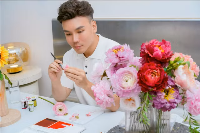 Anh Trọng Tín đang vẽ cánh hoa giấy gạo. Ảnh: THƯỢNG HẢI