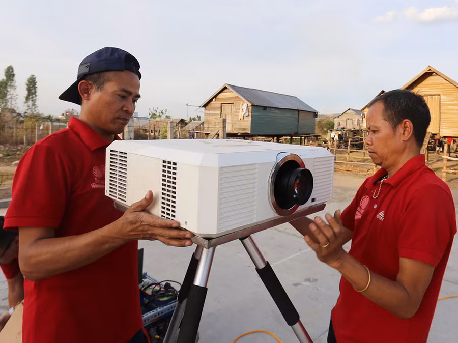 Các cán bộ của Đội chiếu phim lưu động tất bật lắp đặt máy chiếu chuẩn bị cho buổi chiếu phim. Ảnh: Văn Ngọc