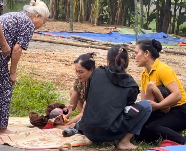 Người dân đỡ đẻ cho sản phụ Hằng sinh con ngay bên lề đường. Ảnh:CTV