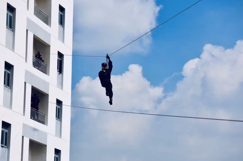 Bài tập đu dây qua các tòa nhà của các nữ chiến sĩ cảnh sát đặc nhiệm. Ảnh: NAM VY