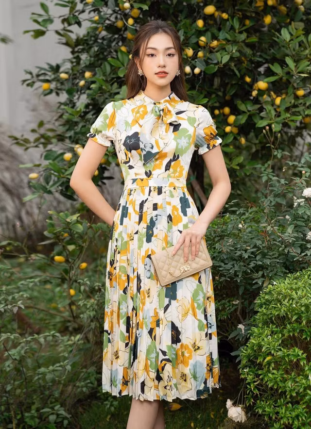 Với thiết kế bắt mắt và ấn tượng, chiếc đầm này sẽ là lựa chọn hoàn hảo khi mặc đến công sở hoặc thậm chí là đi tiệc trong hè này. Với chất liệu thoáng mát và gam màu tươi sáng, chi tiết tay áo phồng và phần cổ thắt nơ, nàng sẽ luôn cảm thấy xinh đẹp và tự tin mỗi khi sải bước.