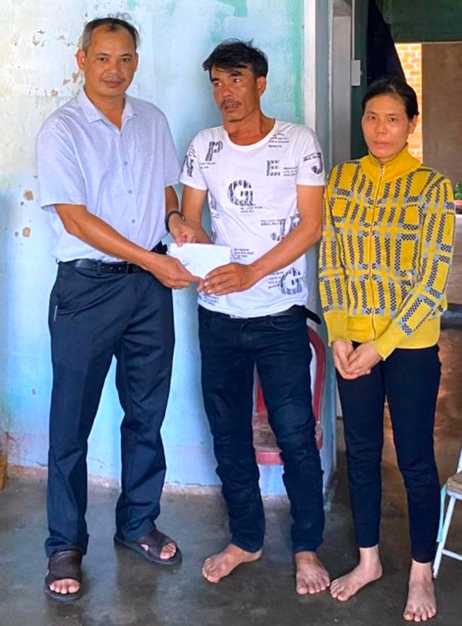 Cán bộ Ủy ban MTTQ Việt Nam phường Tây Sơn (bìa trái) thăm, tặng quà hộ nghèo trên địa bàn. Ảnh: A.P