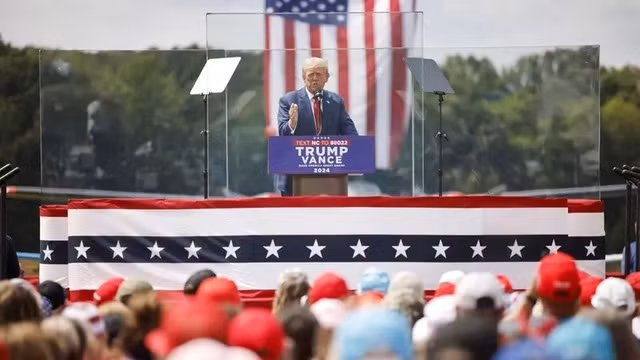 Ông Trump phát biểu sau lớp kính chống đạn trong cuộc vận động tranh cử ở TP Asheboro, bang North Carolina, ngày 21-8 - Ảnh: Reuters