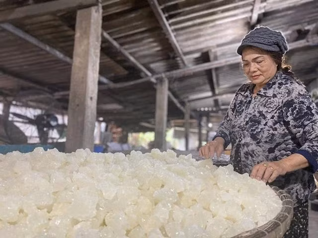 Bà Trần Thị Mỹ Dung bên mẻ đường phèn trắng tinh vừa mới đục ra. Ảnh: HẢI PHONG