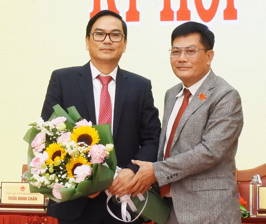 Chủ tịch HĐND huyện Đak Đoa Nguyễn Hữu Thọ (bìa phải) tặng hoa chúc mừng tân Chủ tịch UBND huyện Bùi Thanh Bình. Ảnh: Thanh Nhật