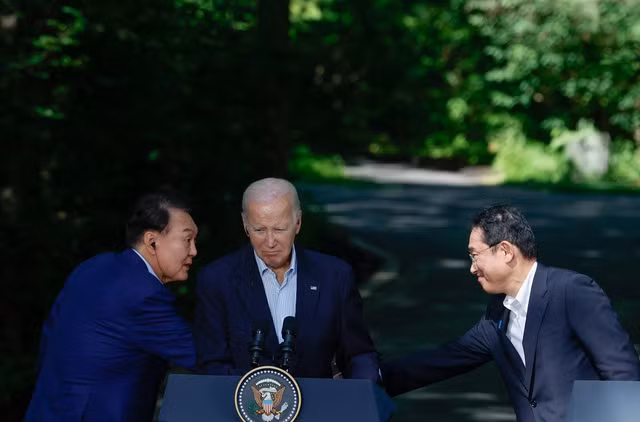 Thủ tướng Nhật Bản Fumio Kishida bắt tay với Tổng thống Hàn Quốc Yoon Suk Yeol trong cuộc họp báo chung với Tổng thống Mỹ Joe Biden trong hội nghị thượng đỉnh 3 bên tại Trại David ngày 18.8. Ảnh: Reuters