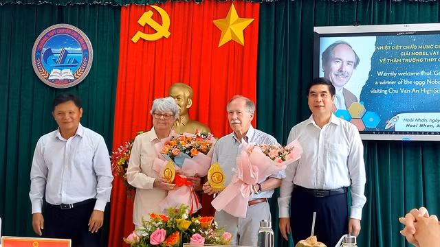 Lãnh đạo UBND tỉnh Bình Định tặng hoa cho vợ chồng GS Gerard t'Hooft. Ảnh: THANH SƠN