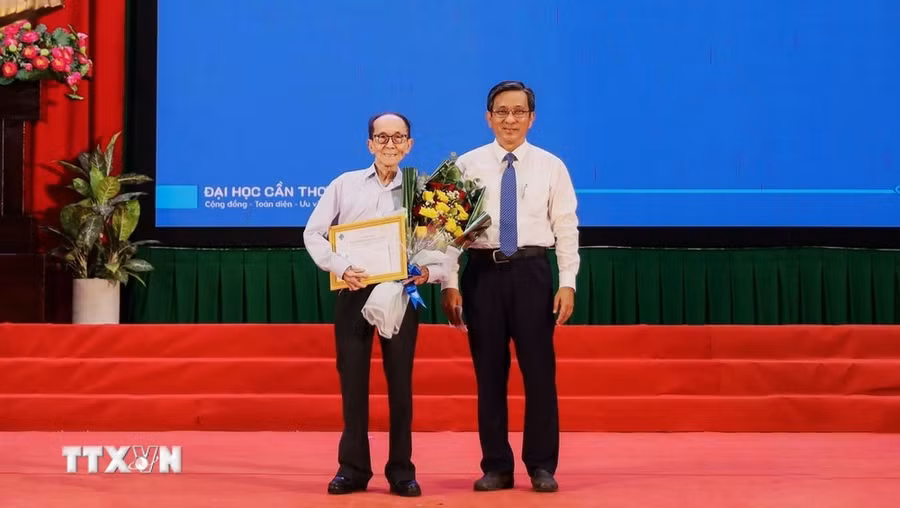Phó Giáo sư, Tiến sỹ Trần Trung Tính, Hiệu trưởng Trường Đại học Cần Thơ trao giấy khen và học bổng toàn phần cho cụ Nguyễn Tấn Thành. (Ảnh: Ánh Tuyết/ TTXVN)