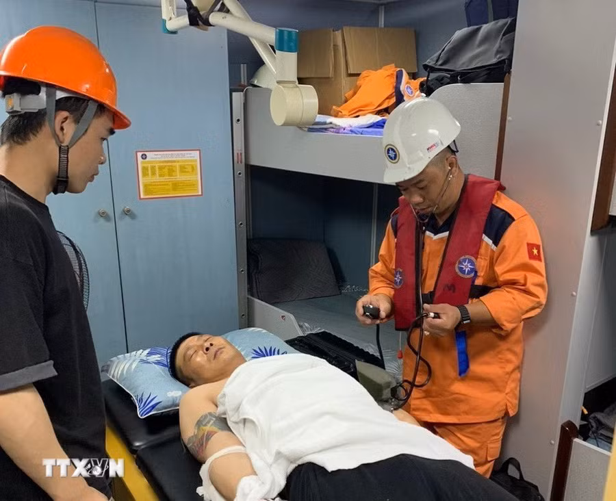 Lực lượng Trung tâm Phối hợp tìm kiếm, cứu nạn hàng hải Việt Nam khu vực IV kiểm tra sức khỏe của bệnh nhân trước khi tiếp nhận đưa về đất liền. (Ảnh: TTXVN phát)