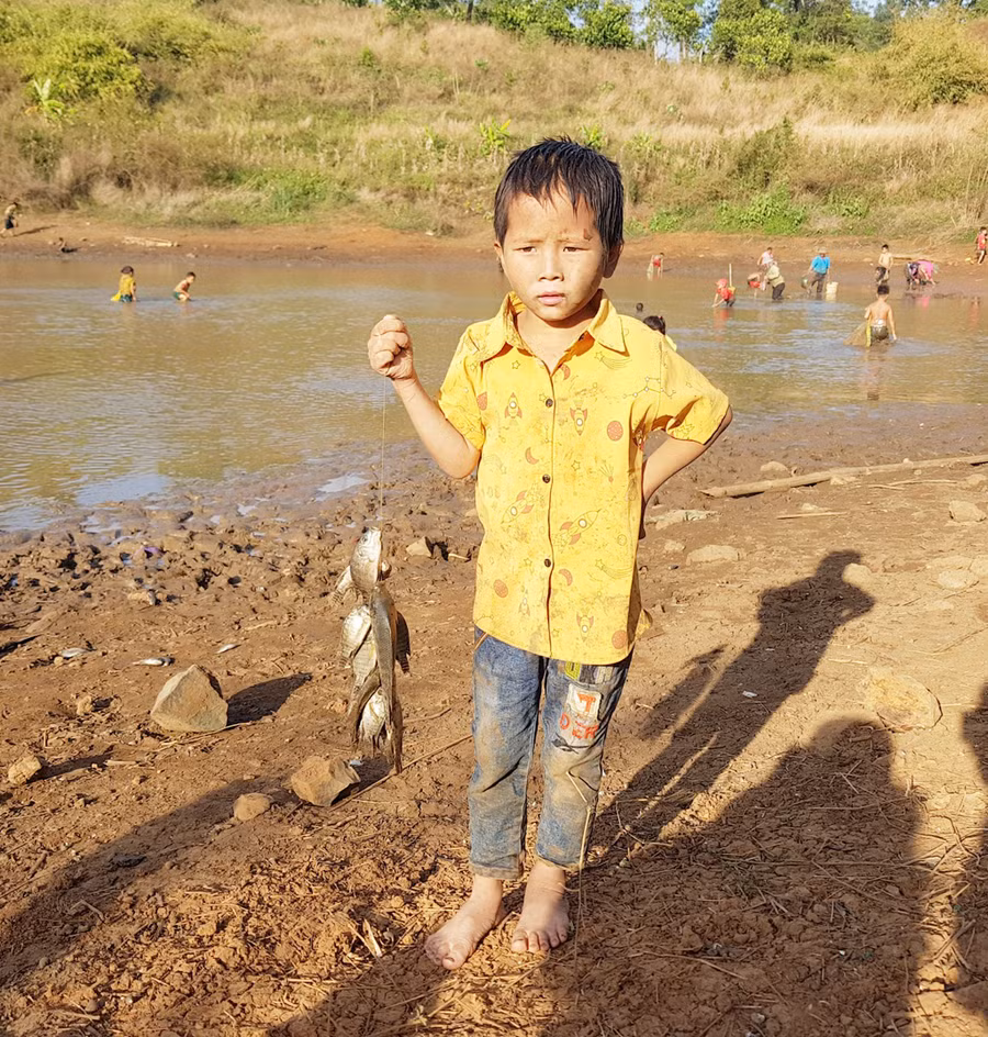 Cậu bé bắt được một xâu cá rô, chúng tôi bắt chuyện nhưng cậu khá rụt rè