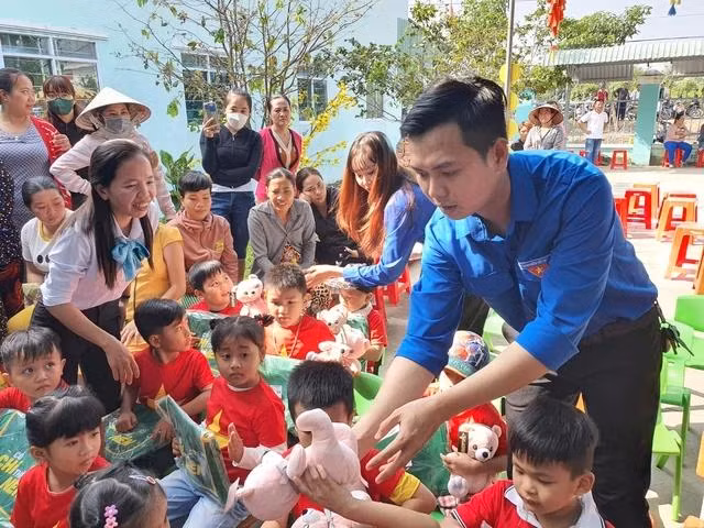 Anh Trần Hoàng Đông phát quà cho học sinh có hoàn cảnh khó khăn. Ảnh: DUY TÂN