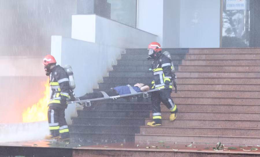Lực lượng cứu nạn cứu hộ diễn tập đưa người bị thương từ trong trụ sở liên cơ quan tỉnh ra ngoài để sơ cấp cứu. Ảnh: T.D