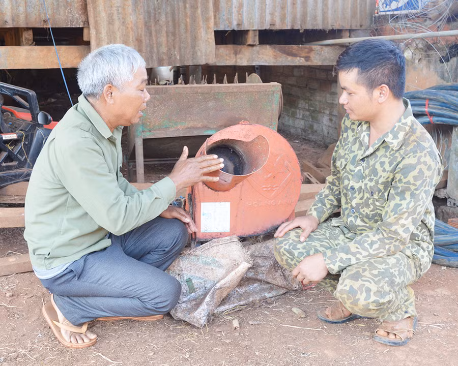 Ông Siu Bốk (bên trái) giới thiệu về máy thái đa năng. Ảnh: Phương Dung