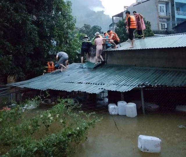 Lực lượng cứu nạn dỡ mái nhà cứu 4 người mắc kẹt ở thành phố Hà Giang. Ảnh HỒNG MINH