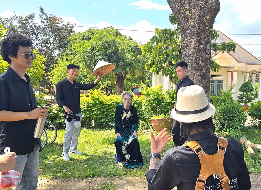 Các bạn trẻ tham gia chương trình "Tấm ảnh yêu thương" đang chụp ảnh chân dung cho một cụ già tại Trung tâm Bảo trợ Xã hội tổng hợp tỉnh. Ảnh: Phương Duyên