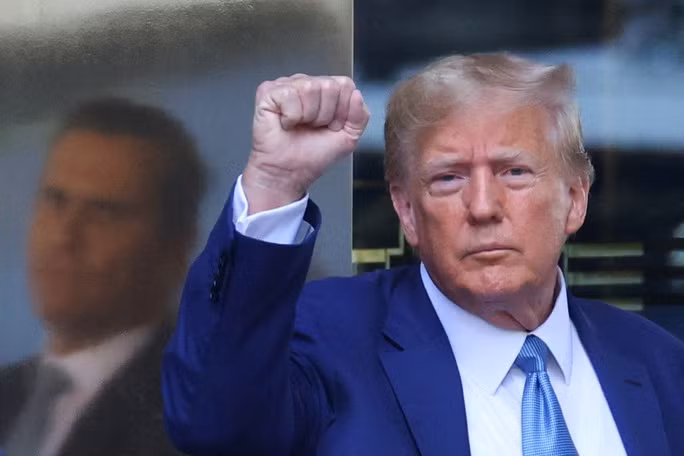 Cựu Tổng thống Donald Trump ra hiệu khi ông rời khỏi toà nhà Trump Tower hôm 13-4. Ảnh: Reuters