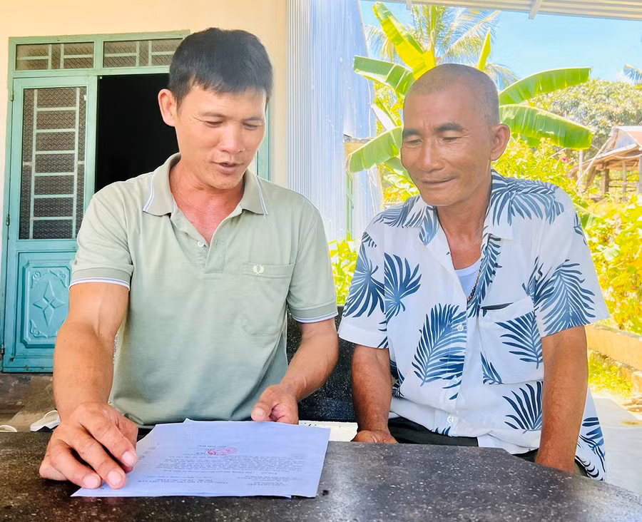 Ông Dương Thành Ngộ (bìa trái) trao đổi nội dung bản tin với ông Hồ Chờ. Ảnh: H.P