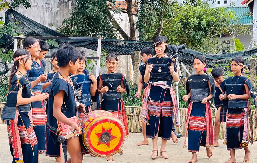 Chị Nguyễn Thị Phượng (ở giữa-du khách Hà Nội) ấn tượng khi được giao lưu với đội cồng chiêng của làng. Ảnh: Mai Ka