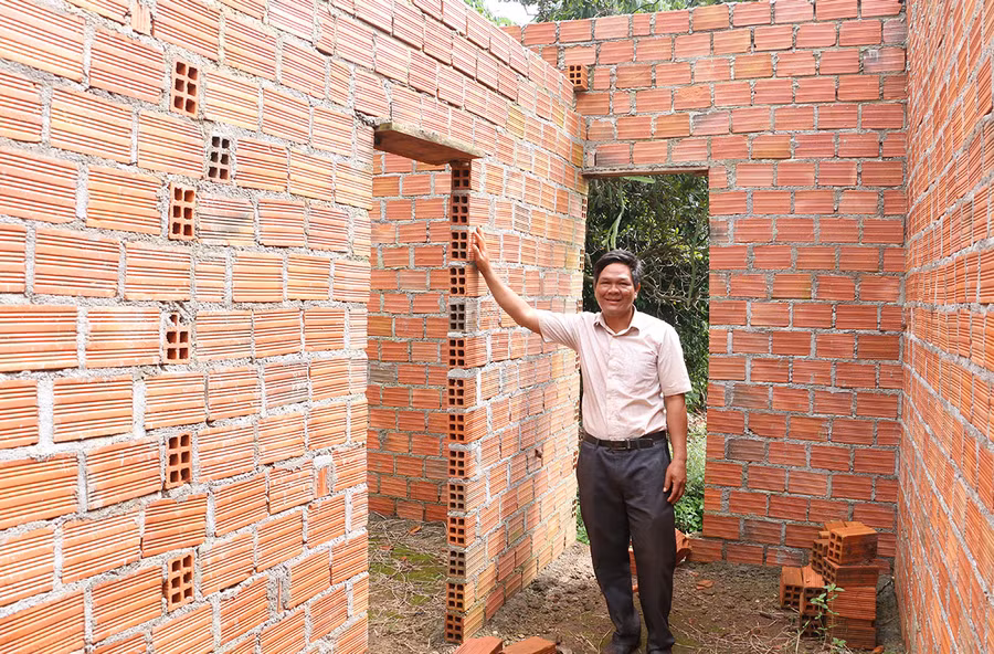 Anh Siu Hrip (làng Chư Pố 2, xã Ia Phang) bên công trình do anh nhận thi công. Ảnh: Q.T